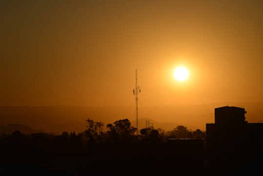 A warm sunrise over Salem with a radio tower broadcasting light beams.