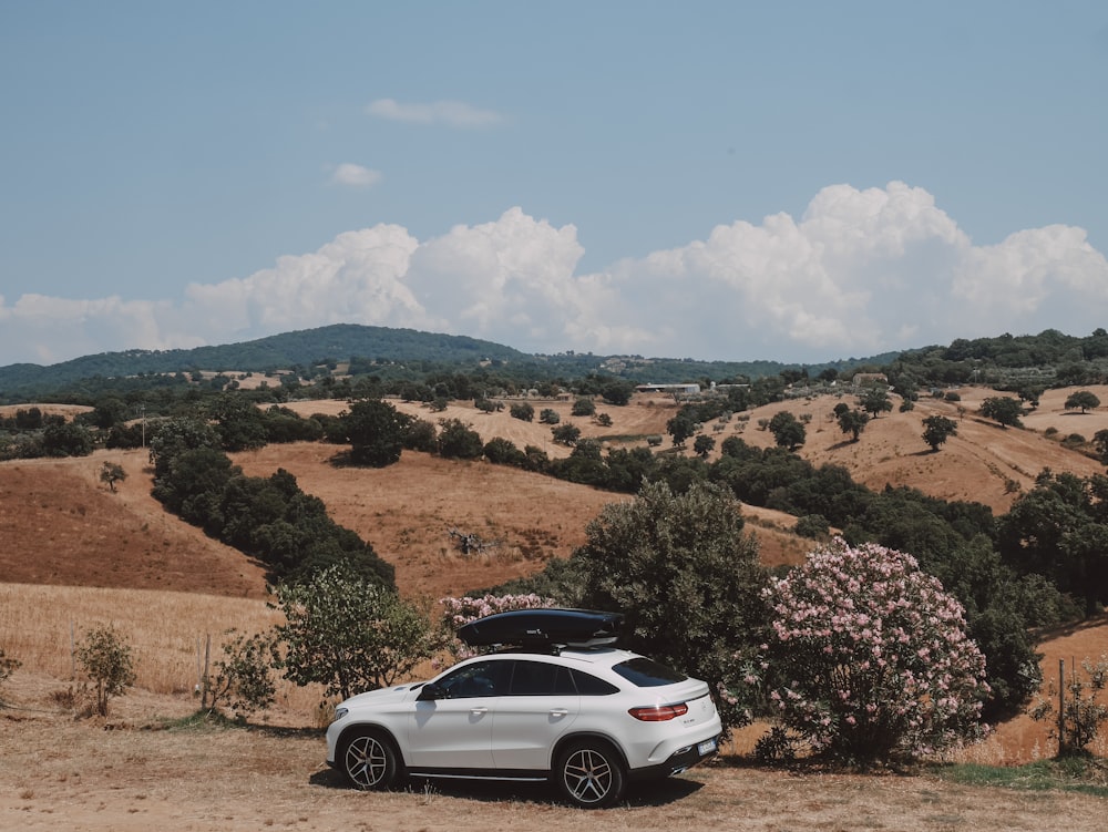 a white car parked on a dirt road