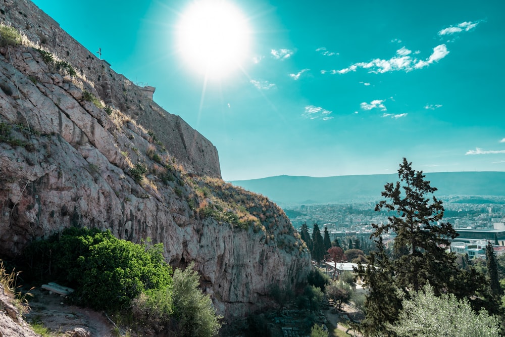 the sun shines brightly over a rocky mountain