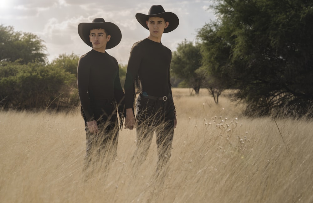 two young men standing in a field of tall grass