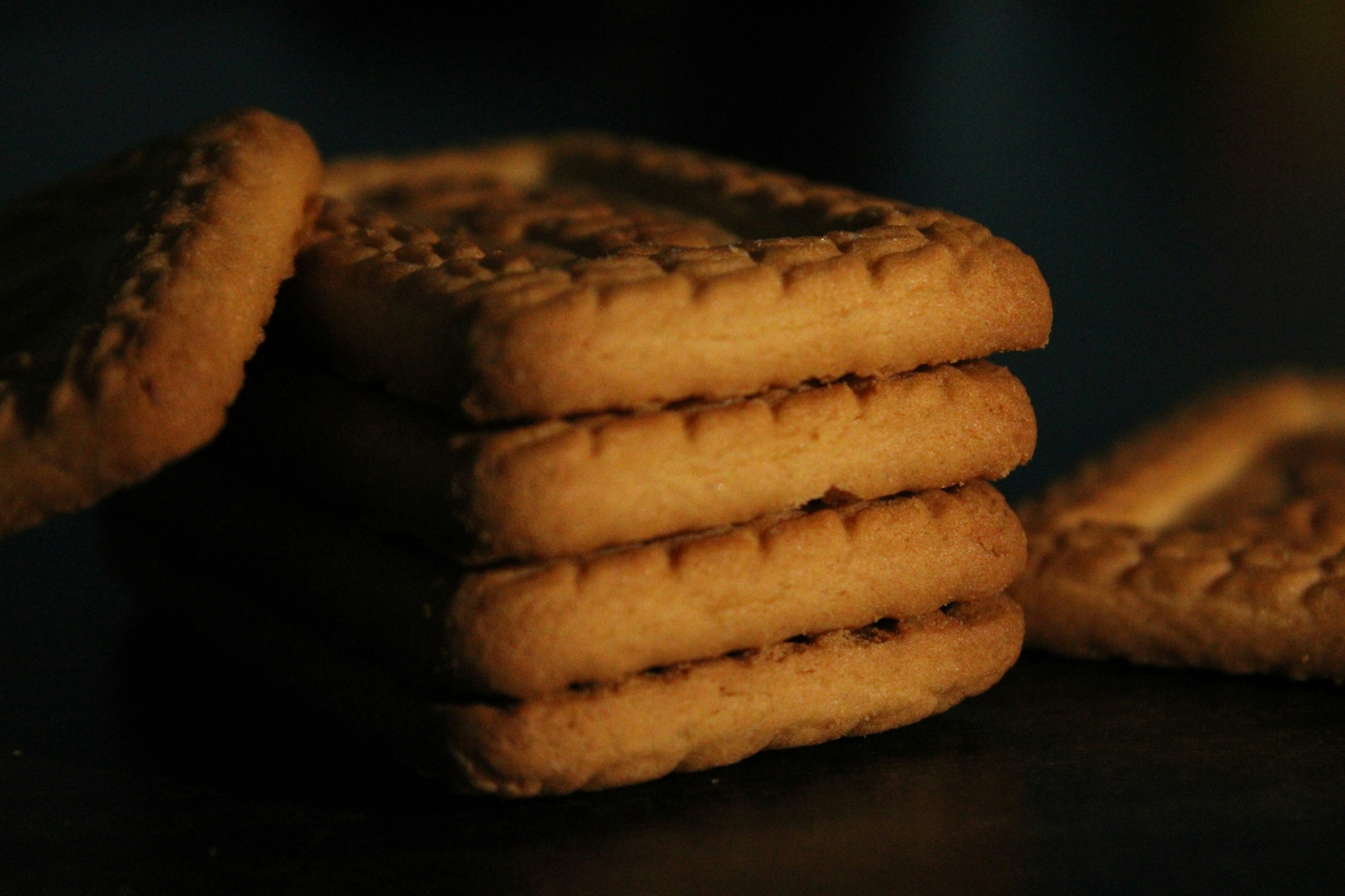 Golden biscuits arranged on a light wooden surface, warm bakery tones, well-lit overhead shot