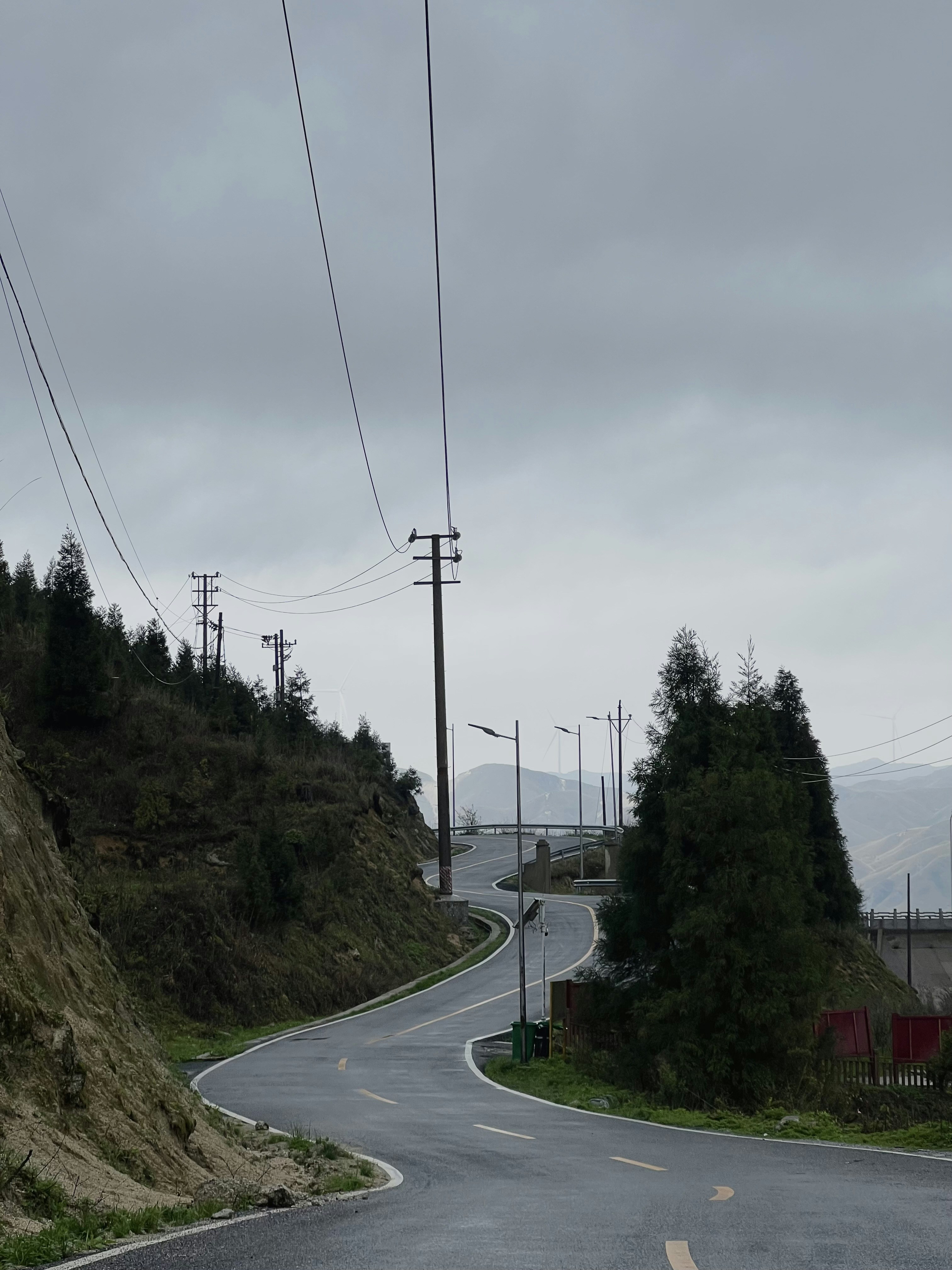a winding road with power lines above it