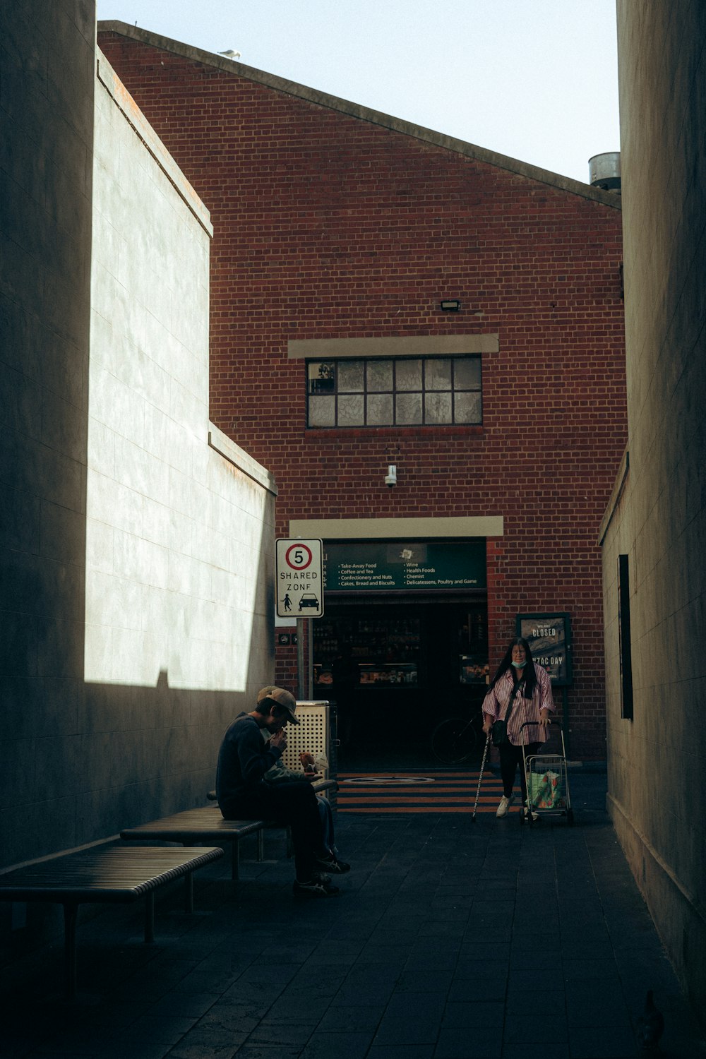 two people sitting on a bench in front of a building