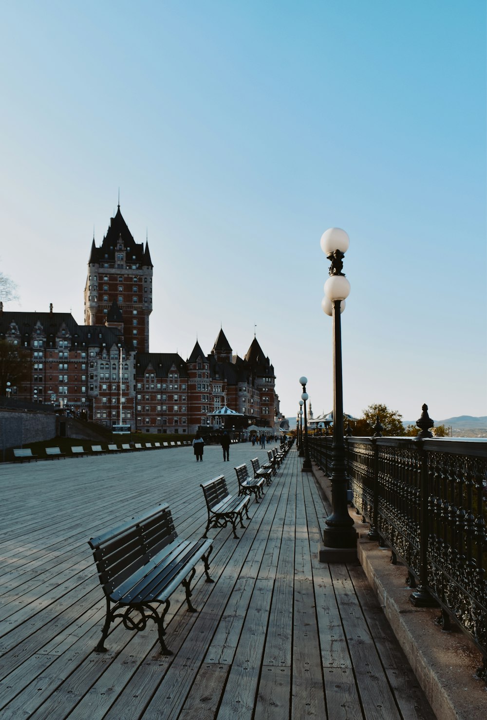 a row of benches sitting on top of a wooden pier