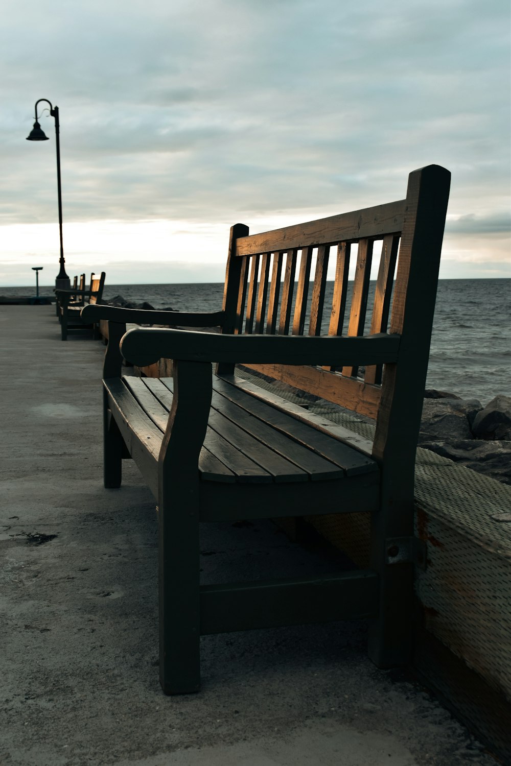 a wooden bench sitting next to the ocean