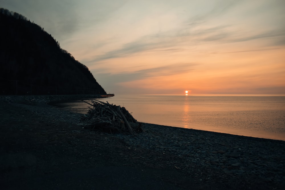 Die Sonne geht über dem Wasser am Strand unter