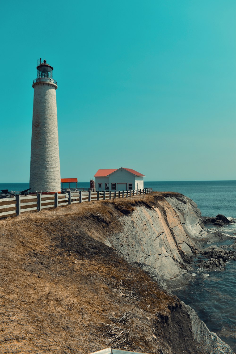 a light house sitting on top of a cliff next to the ocean