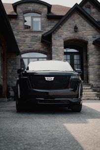 a black car parked in front of a house