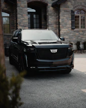 a black suv parked in front of a stone building