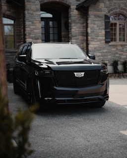 a black suv parked in front of a stone building