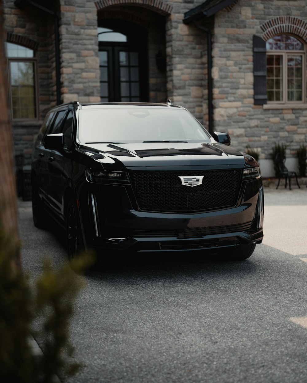 a black suv parked in front of a stone building