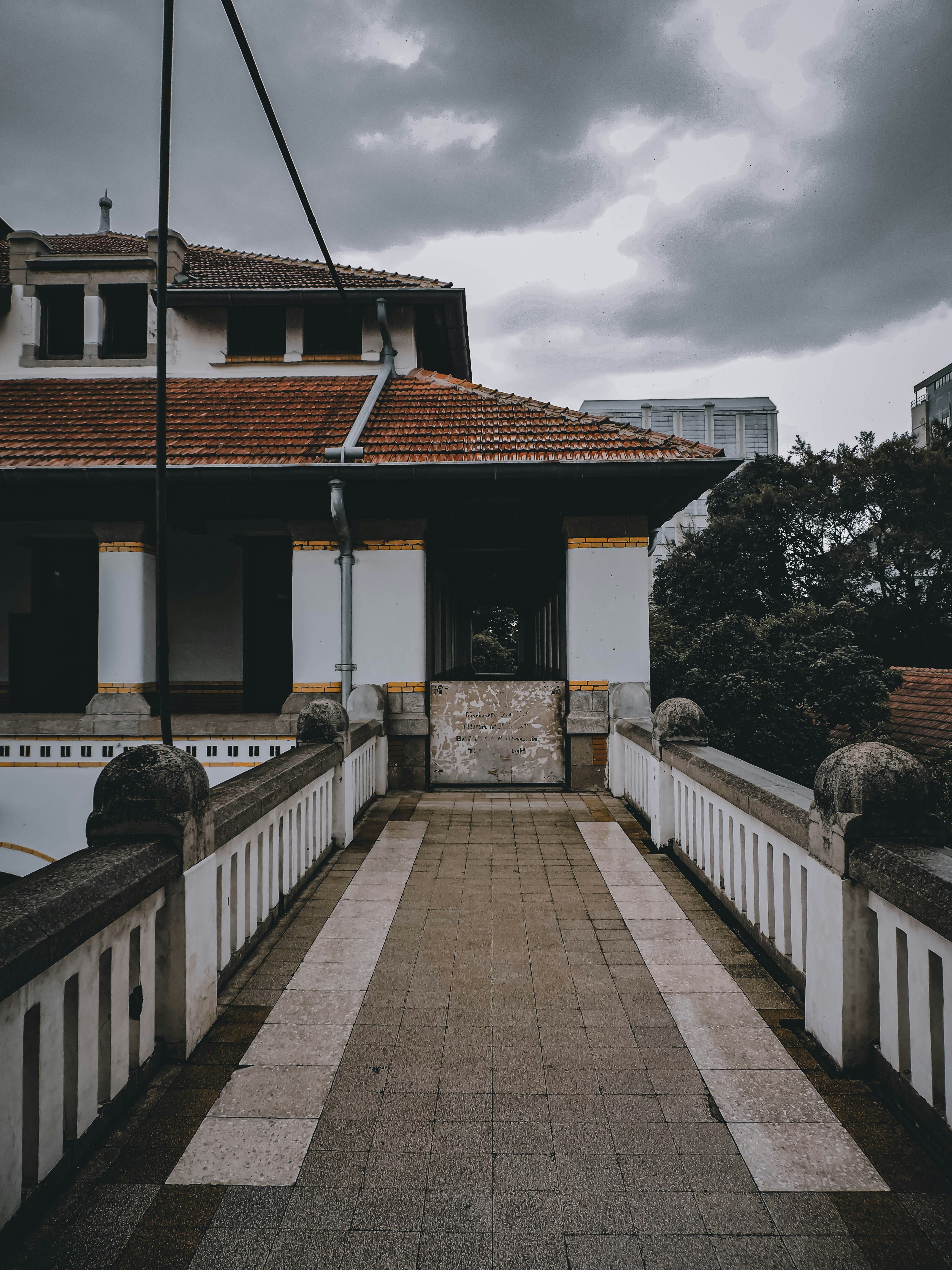 a walkway leading to a building with a red roof