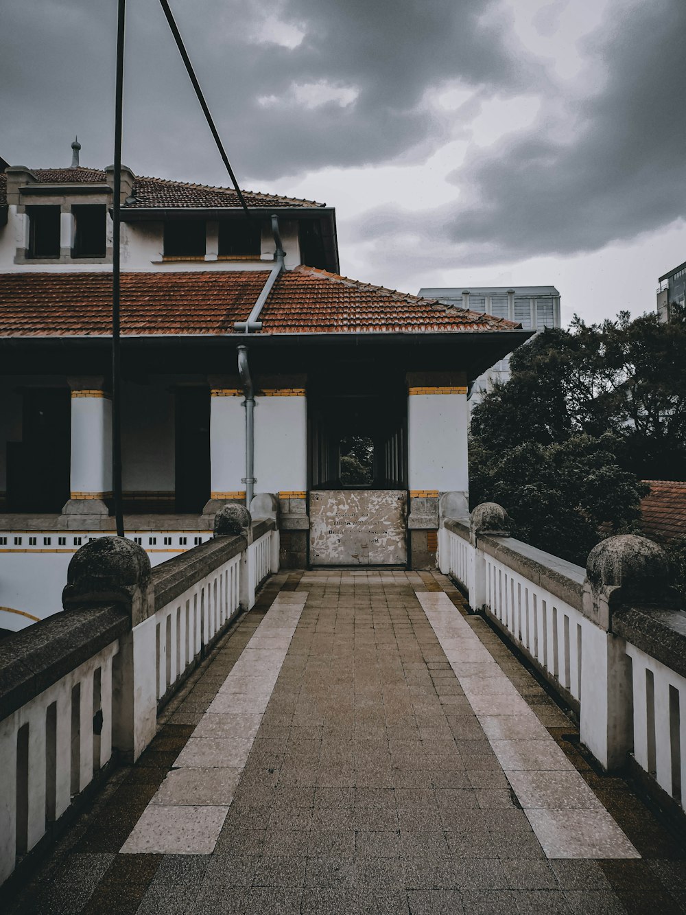 a walkway leading to a building with a red roof