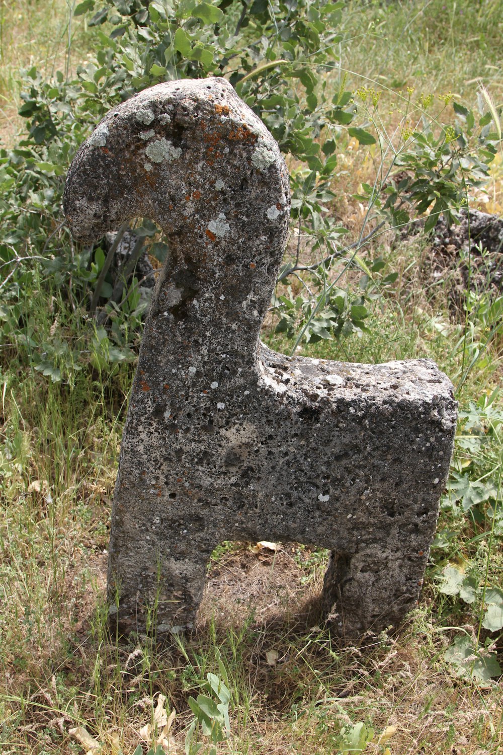 a stone sculpture in the middle of a field