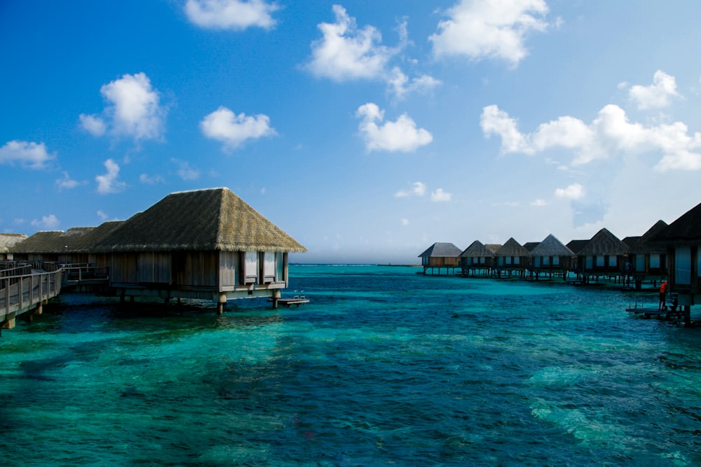 a group of huts sitting on top of a body of water