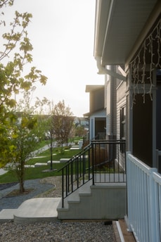 A modern townhouse exterior with a welcoming front porch bathed in warm sunlight.
