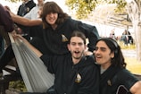 Group of people wearing personalized embroidered hoodies and polos outdoors.