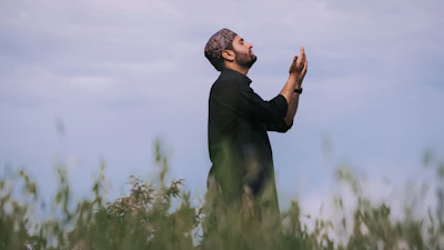 A peaceful moment of a farmer praying in the field at dawn.