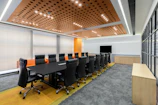 A modern conference room featuring white leather chairs and orange accent lighting.