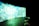 A large, curved screen displays vibrant, abstract patterns with dominant shades of blue and green, creating a surreal and immersive atmosphere. The room is dimly lit, enhancing the luminous effect of the screen. In the foreground, there are several round cushions placed on a concrete floor.