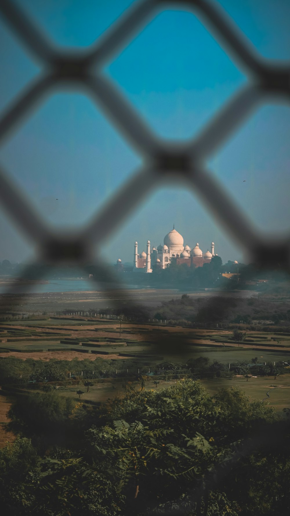 a view of a large white building through a fence