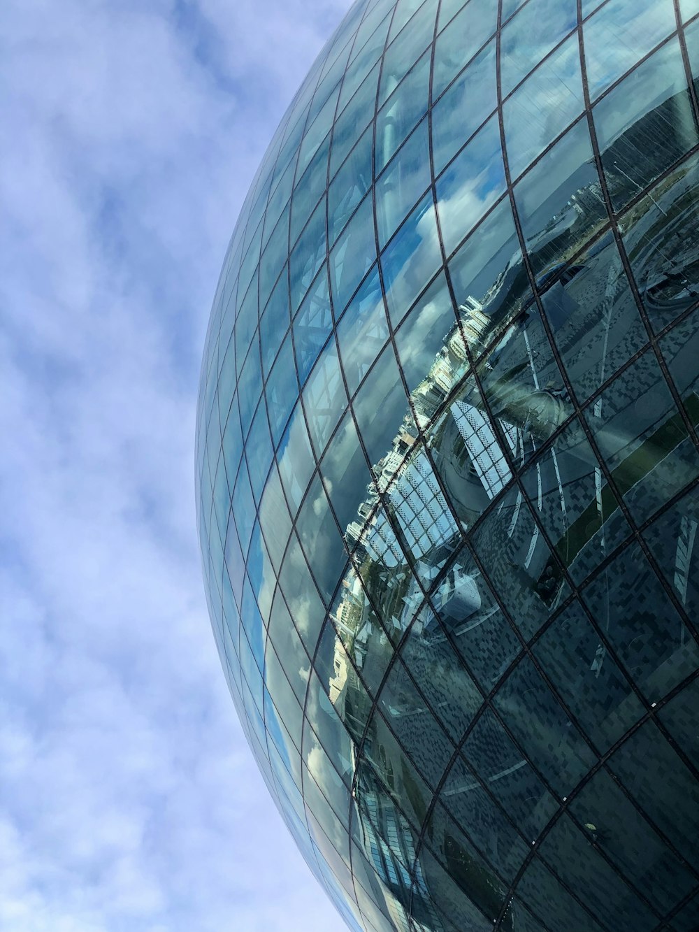 a very large shiny building with a sky in the background