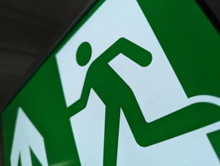 a close up of a green and white street sign