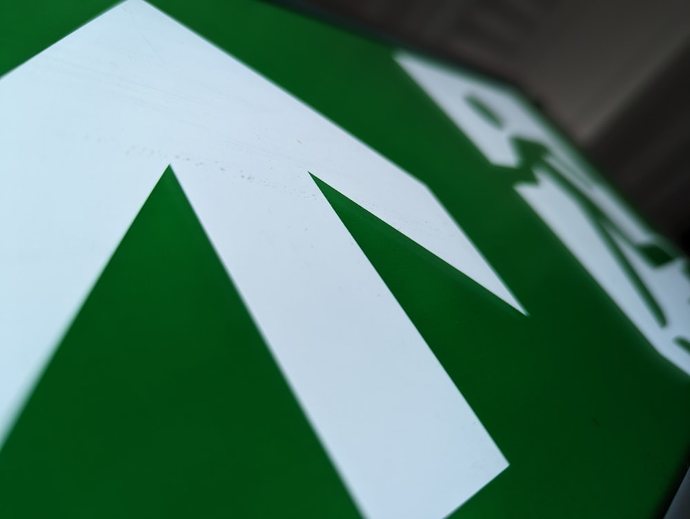 a close up of a green and white street sign