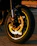 Close-up of a sleek motorcycle wheel with a shiny CNC racing rim under dramatic lighting.