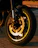 Close-up of a sleek motorcycle wheel with a shiny CNC racing rim under dramatic lighting.