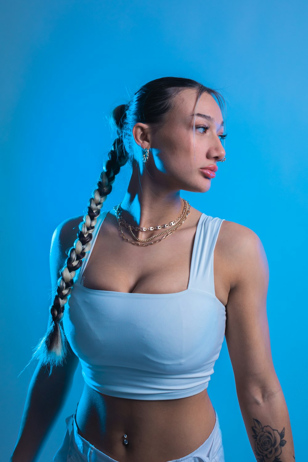 a woman in a white tank top with a braid in her hair