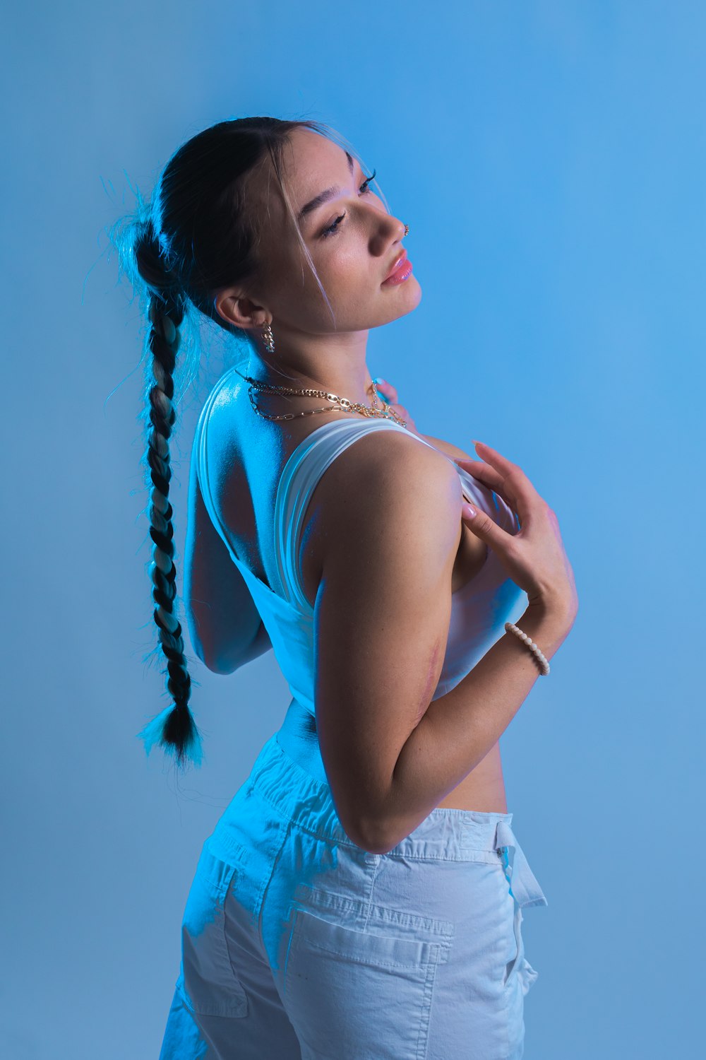 a woman with a ponytail standing in front of a blue background