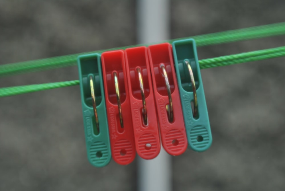 three pairs of red and green scissors hanging on a line