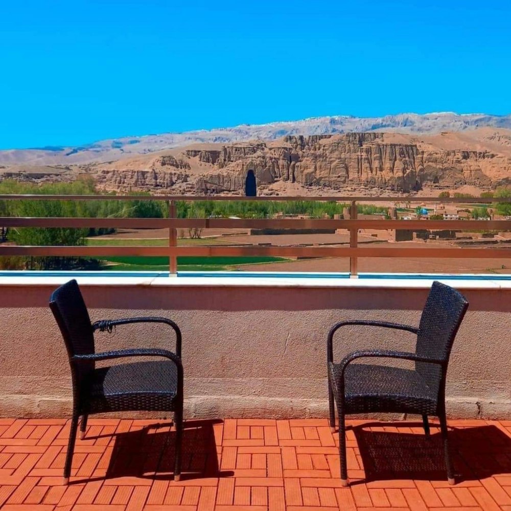 two chairs sitting on a balcony overlooking a mountain range