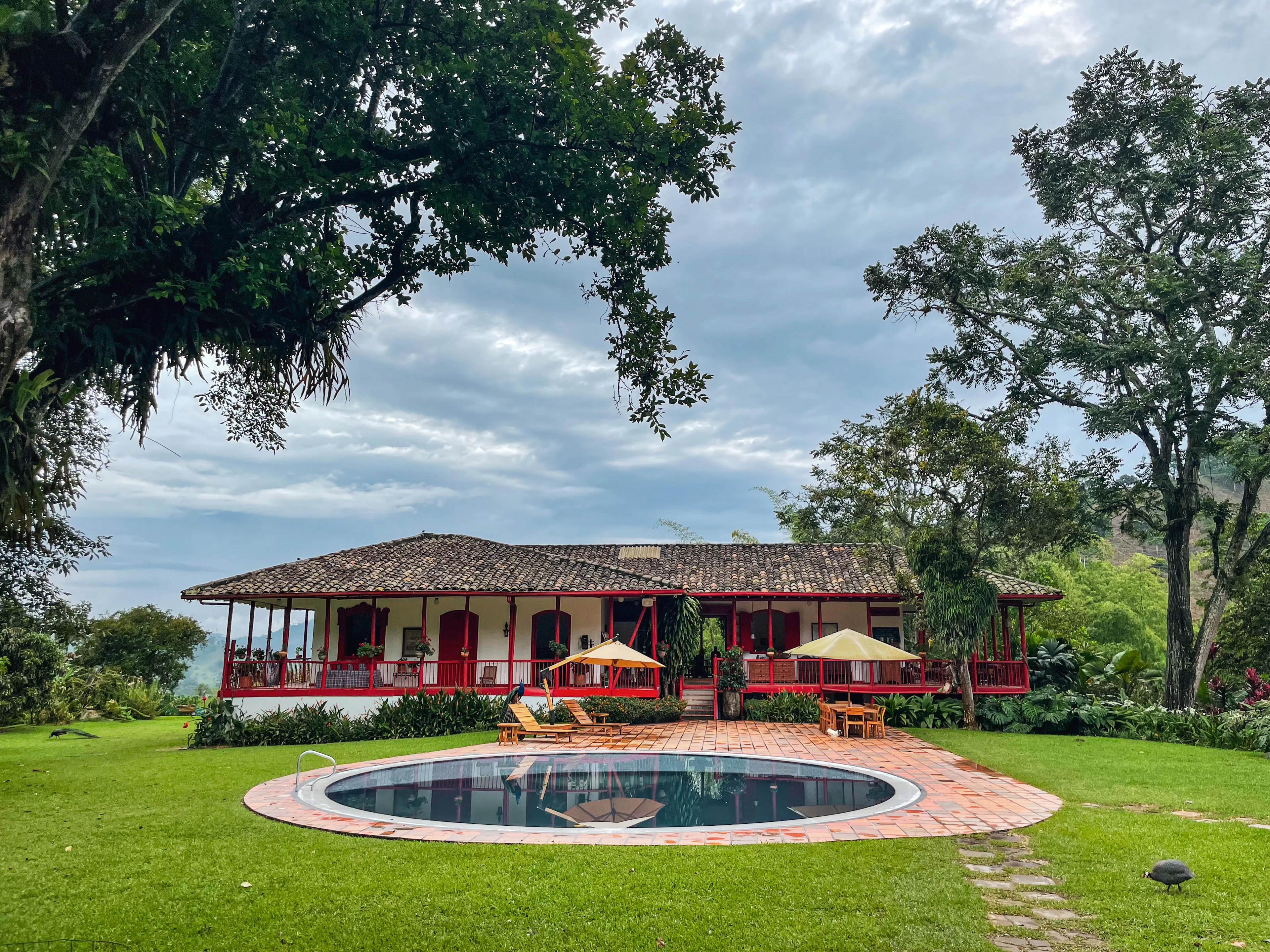 A traditional coffee-farm house with red balconies and a pool among the trees, Caldas, Colombia