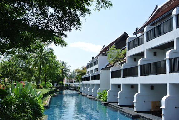 A serene view of the Ramada Resorts & Residences nestled among lush green hills under a clear blue sky.