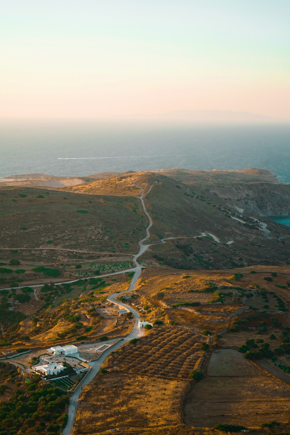 an aerial view of a winding road in the middle of a field