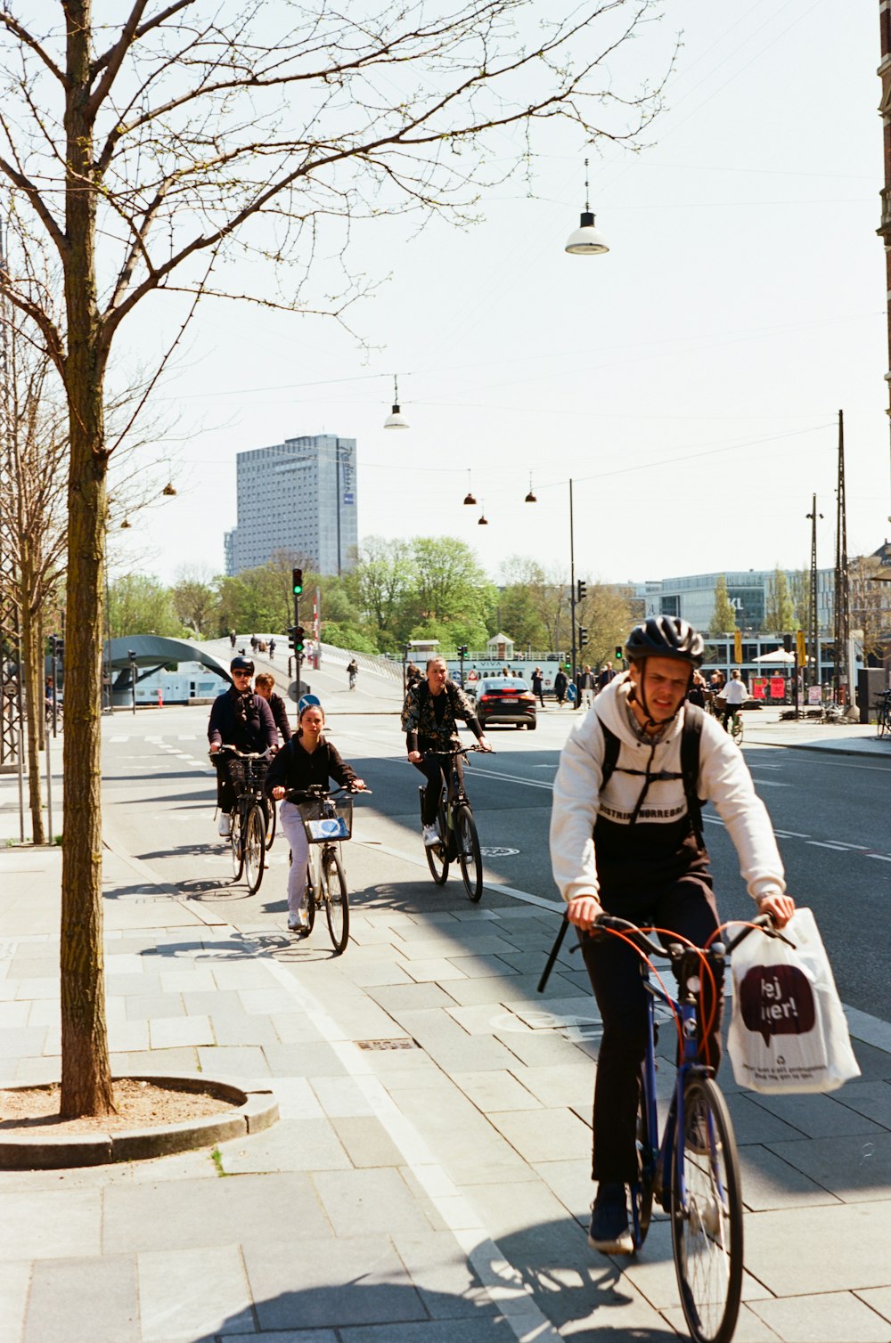 a group of people riding bikes down a street