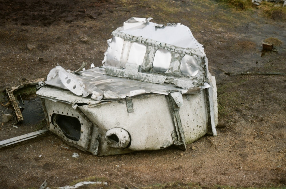 a broken microwave oven sitting on top of a dirt field