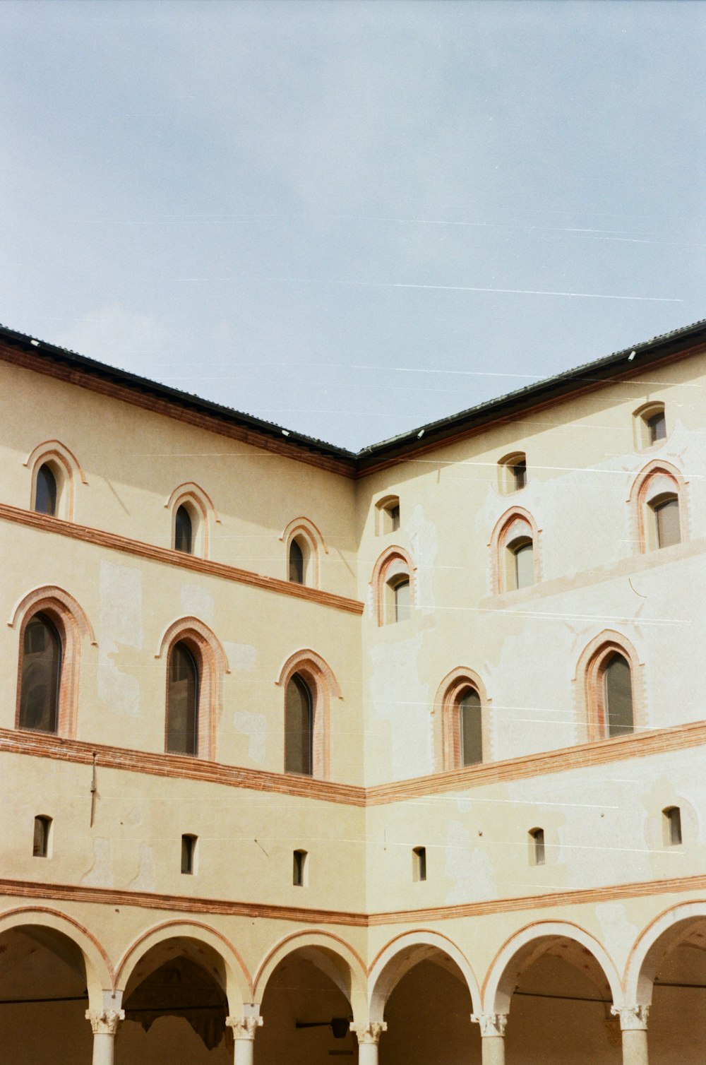 a building with arches and a clock on the front of it