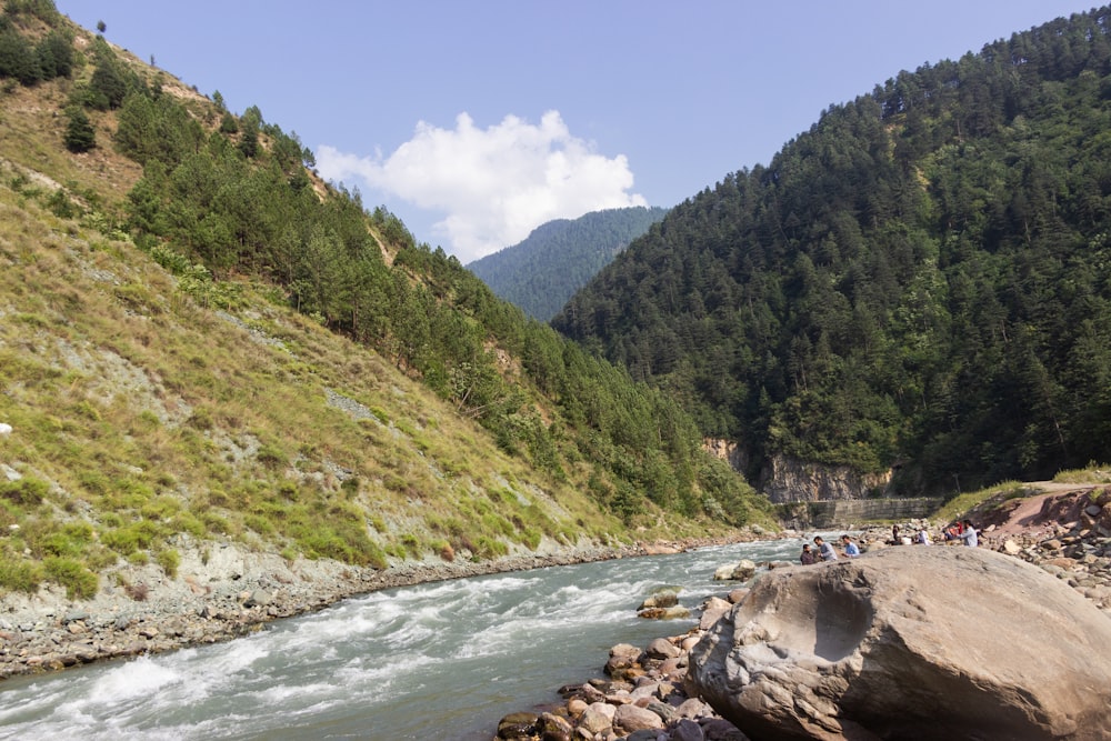 a group of people standing on the side of a river