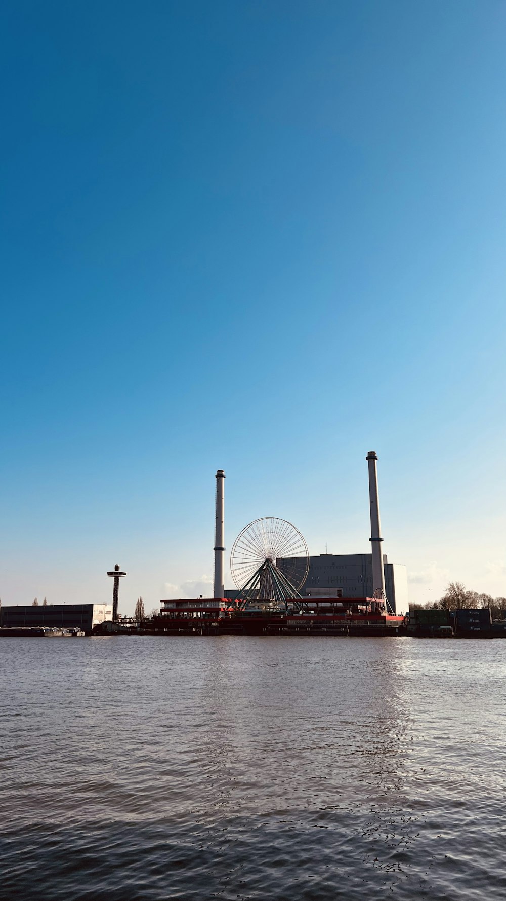 a large body of water with a ferris wheel in the background