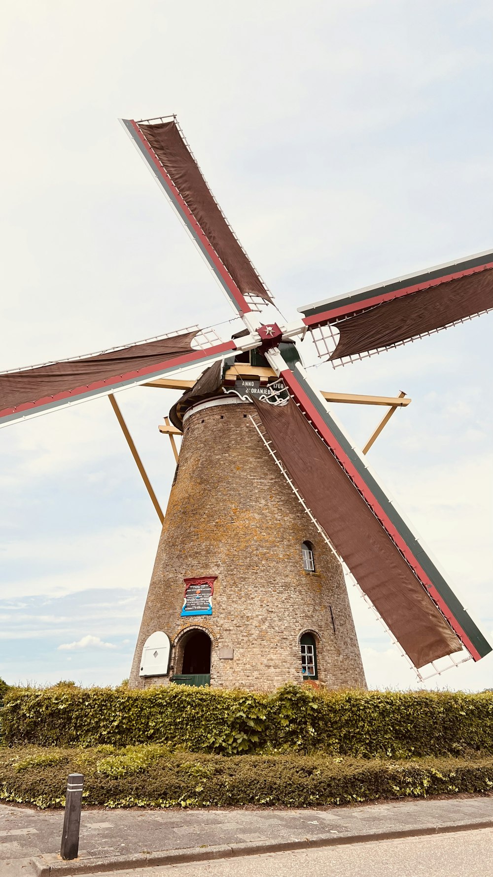 a windmill sitting on top of a lush green field