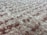 A close-up view of a fluffy, textured carpet with a blend of soft fibers. The surface is thick and plush, showcasing a uniform pattern with a slightly irregular arrangement that gives a sense of depth.