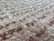 A close-up view of a fluffy, textured carpet with a blend of soft fibers. The surface is thick and plush, showcasing a uniform pattern with a slightly irregular arrangement that gives a sense of depth.