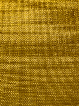 A close-up view of a textured fabric surface with a tight and even weave. The fabric appears to be made of thick threads, tightly interwoven in a grid pattern.