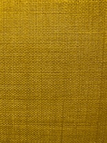 A close-up view of a textured fabric surface with a tight and even weave. The fabric appears to be made of thick threads, tightly interwoven in a grid pattern.