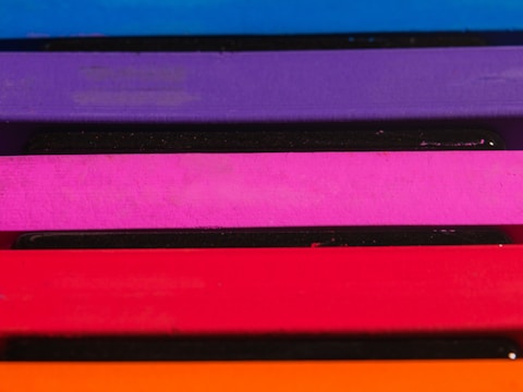 Multiple horizontal layers of vibrant colors stacked vertically, including blue, purple, pink, red, and orange.