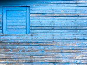 Close-up of a freshly painted blue and white exterior wall on a house in Nîmes.