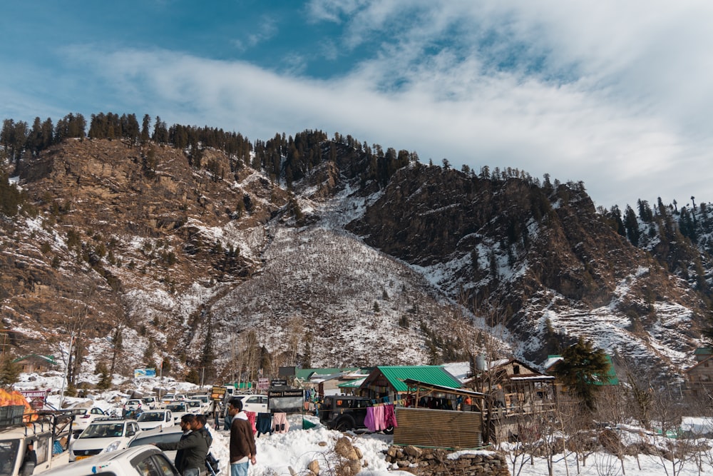 a group of people standing in the snow near a mountain